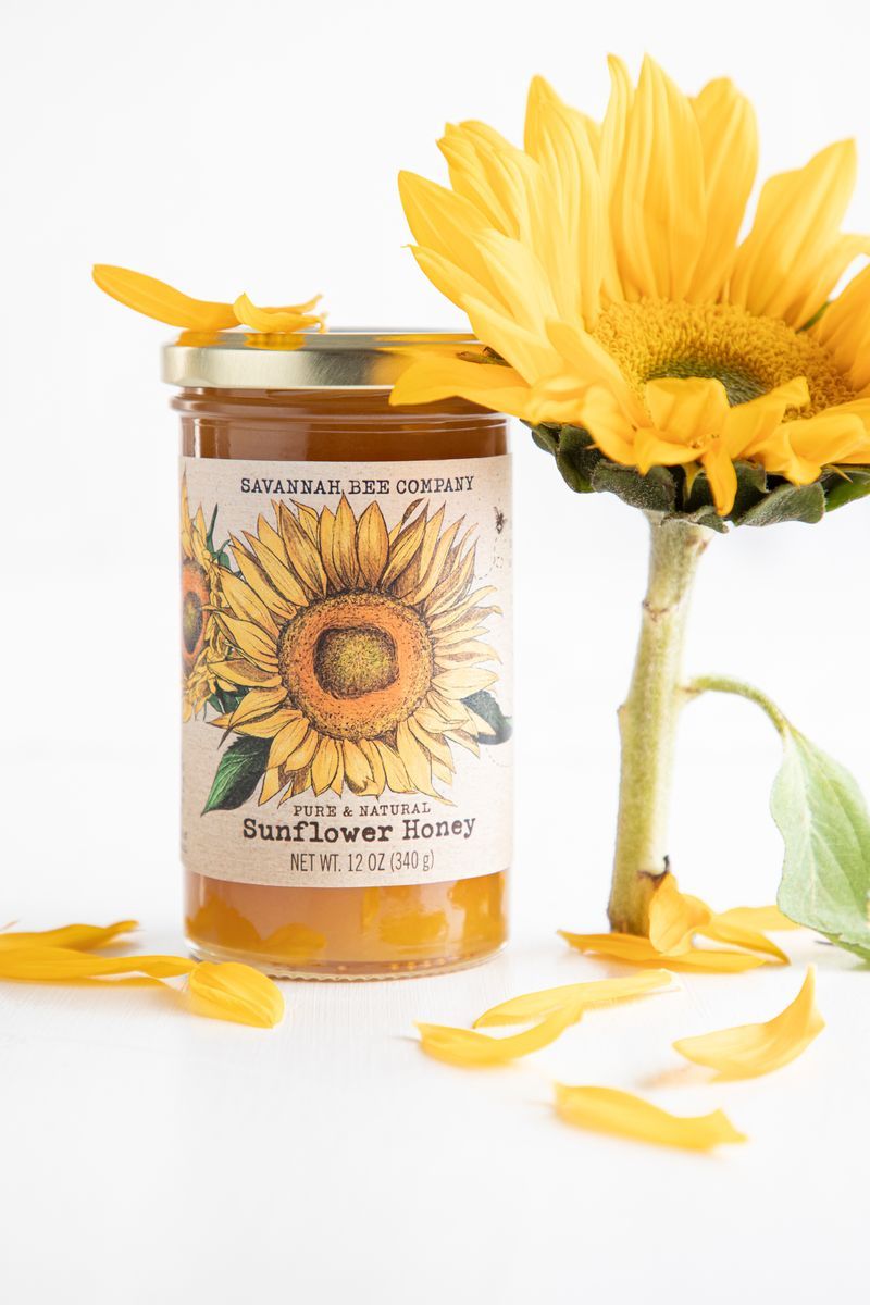Sunflower next to a jar of sunflower honey.