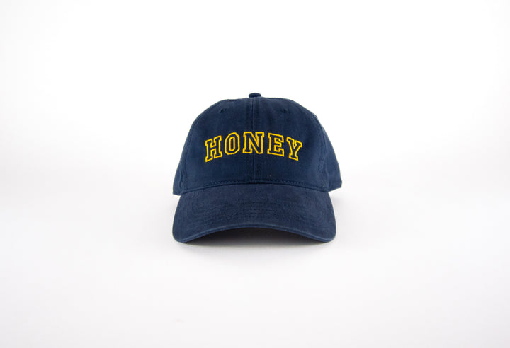 Navy blue cap with 'HONEY' embroidered in yellow on a white background